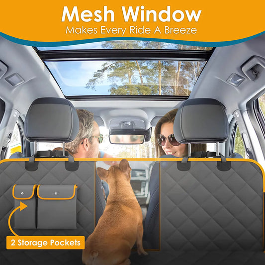 Dog looking through the mesh window of the seat hammock towards the front seats